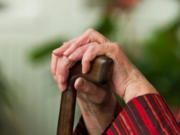 პენსიონერი ქალი ყავარჯნით ხელში